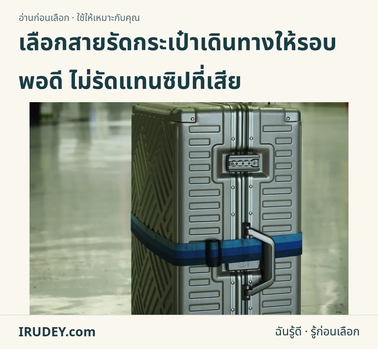 กระเป๋าเดินทางสีเงินคาดสายรัดสีน้ำเงินในอาคารผู้โดยสาร