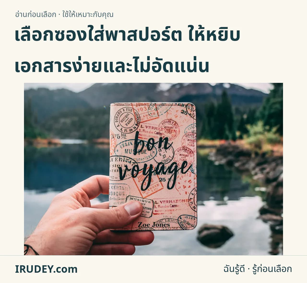มือจับปกพาสปอร์ตสีอ่อนโดยมีภูเขาอยู่ด้านหลัง เป็นบริบทการเดินทาง